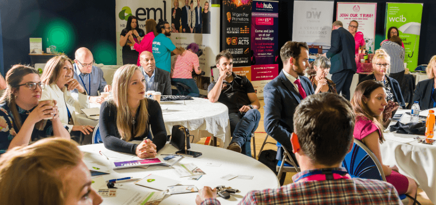 a group of people sitting around a table at a business expo