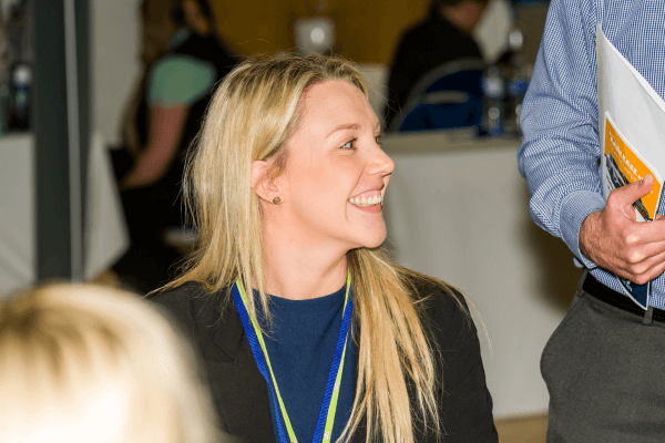 a person and another person sitting at a table talking to each other networking