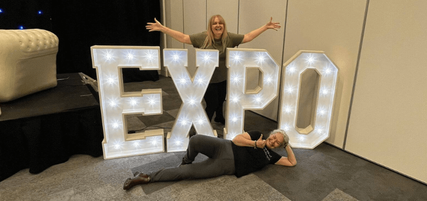 two people stood with large light up letters spelling 'Expo'