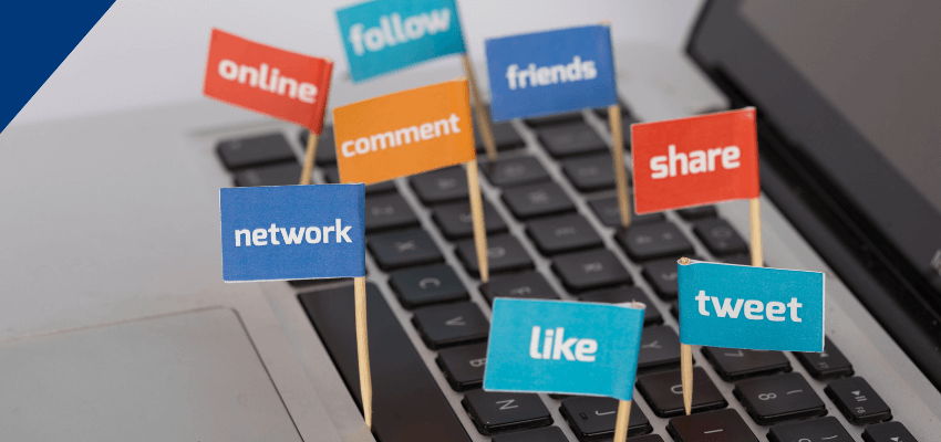 Laptop keyboard with small colourful flags showing social media actions like follow, comment, share, like, tweet, and network.